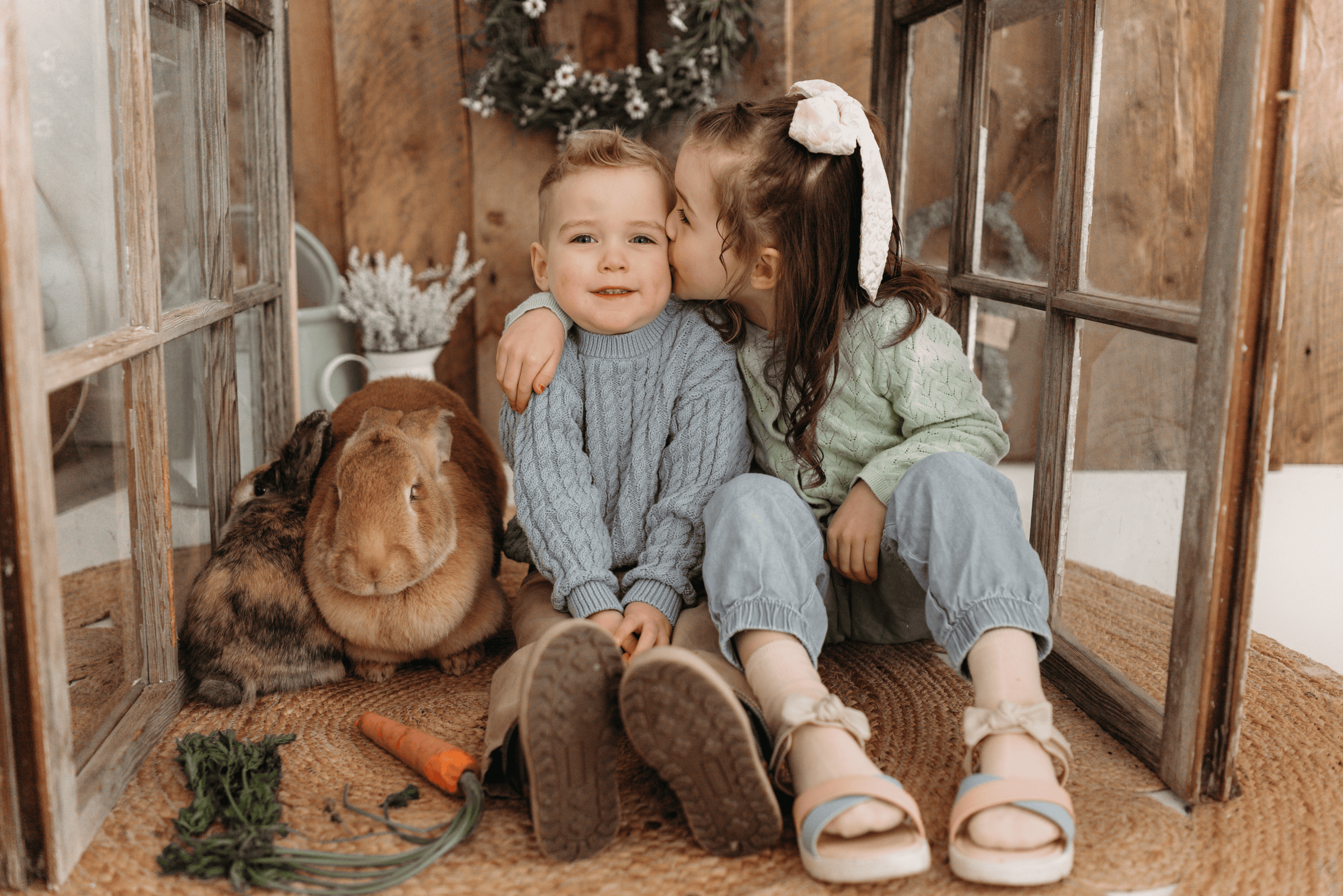 Cute kids with bunny and carrots in cozy setting.