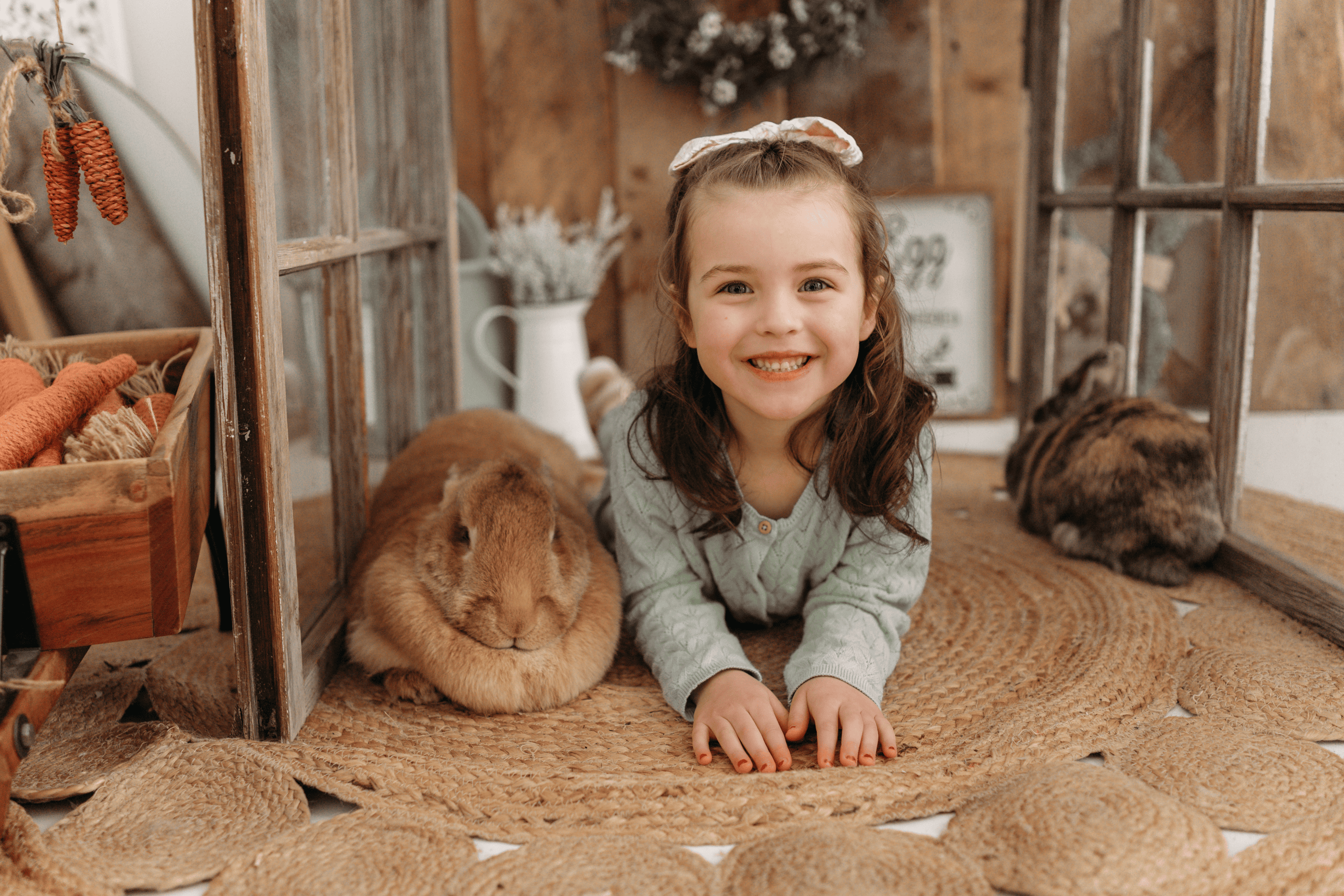 Cute girl with rabbits in cozy indoor setting for family and seasonal mini sessions.