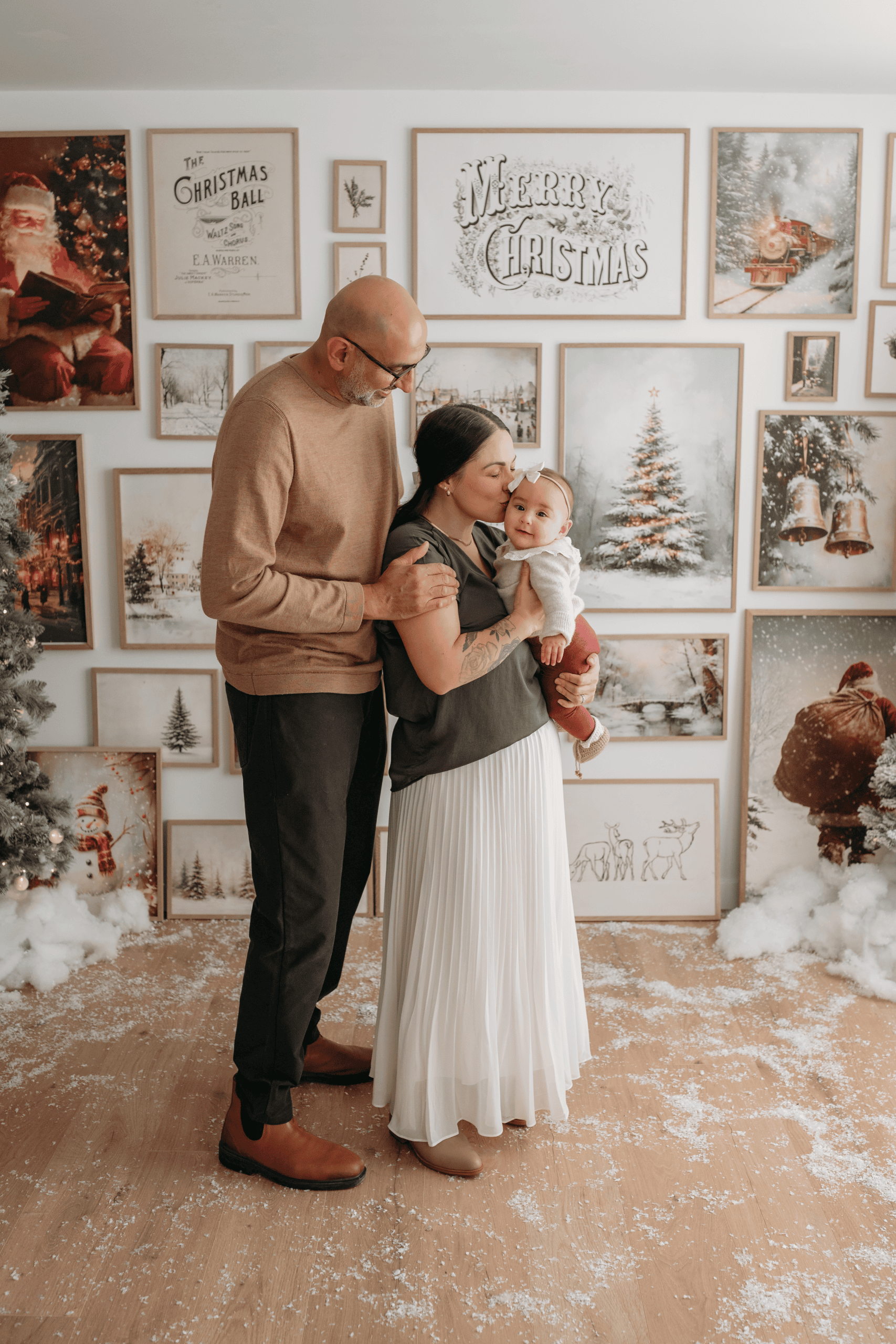 Family celebrating Christmas with baby in front of festive holiday decor in Prince George.